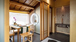 A traditional Japanese-style room with tatami flooring, a low wooden table, and a shoji screen door. - West Lake Teavilla (Hangzhou)