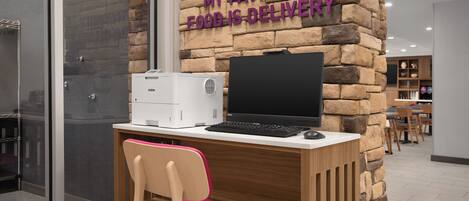 Un espacio de oficina moderno con una pared de piedra, un escritorio con computadora y una silla.