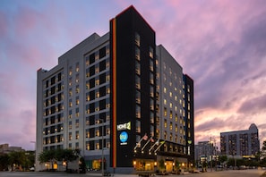 A multi-story hotel with a prominent "HOME 2" sign, multiple windows, and a well-lit entrance. - Tru by Hilton Houston Downtown Convention Center (Houston)