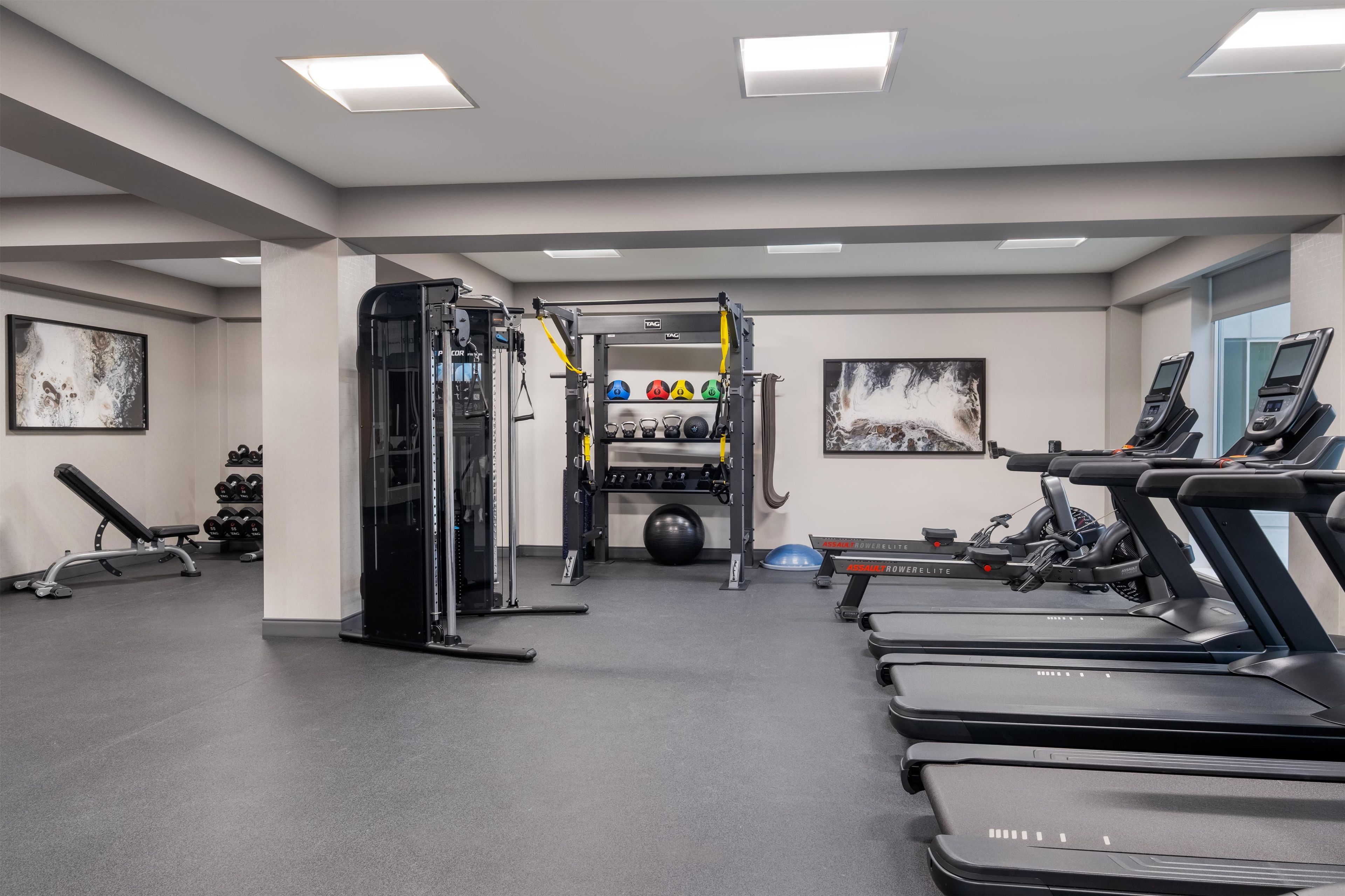 A gym with treadmills, weight machines, and exercise balls.