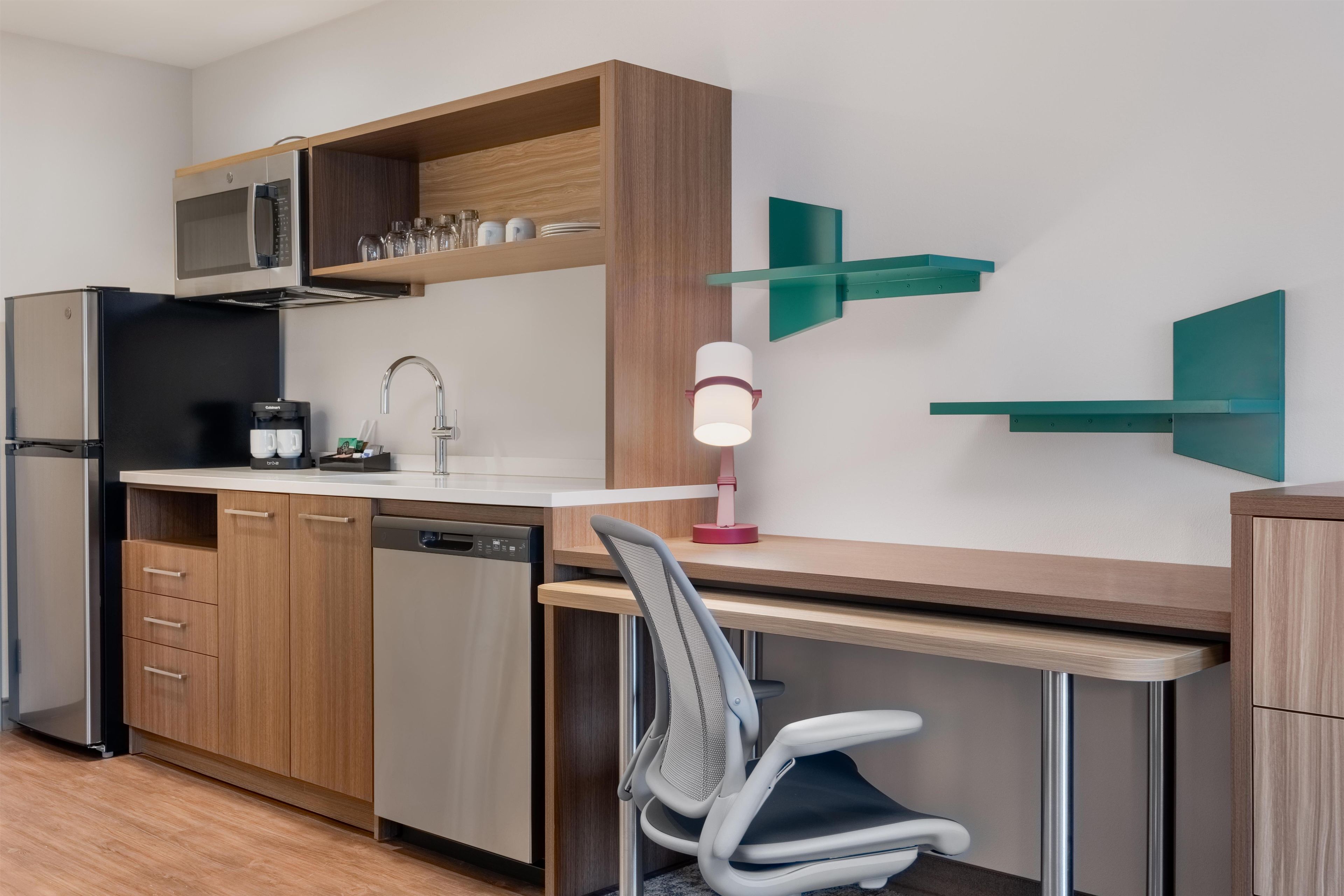 A modern kitchen with a built-in dishwasher, a coffee machine, and a microwave.