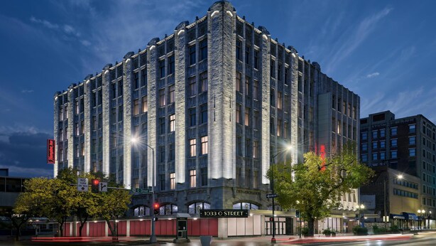 A large, multi-story building with a stone facade and multiple windows. - Hampton Inn by Hilton Lincoln Downtown (Lincoln)