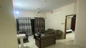 A spacious living area with a sofa, a small table, and a ceiling fan. - Ciatle Suites & Resort  (Dhaka)