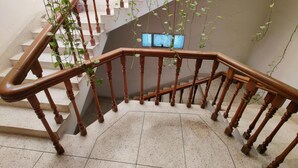 A staircase with wooden balusters and a tiled floor. - Ciatle Suites & Resort  (Dhaka)
