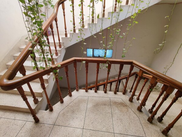 A staircase with wooden balusters and a tiled floor.