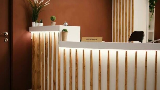 A reception desk with a sign labeled "RECEPTION," a potted plant, and a chair. - Ciatle Suites & Resort  (Dhaka)