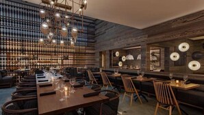 A restaurant with a long wooden table, multiple chairs, and a patterned floor. - Luxury Hotel Room With 2 Queen Beds in Lionshead Village (Vail)