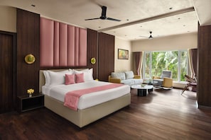 Ein Hotelzimmer mit einem großen Bett, einem Schlafsofa, einem Couchtisch und Blick auf Grün.