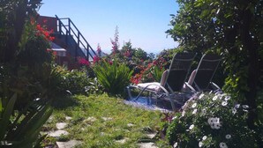 A garden with a pool, lounge chairs, and a staircase leading to a building. - VILLA SILA (El Paso)
