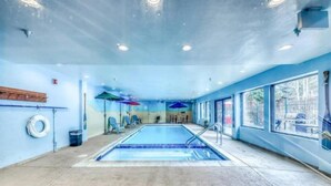 An indoor swimming pool with a clear view of the pool area, a lifeguard chair, and a windowed wall. - Studio Condo at Gateway Lodge in Keystone (Keystone)