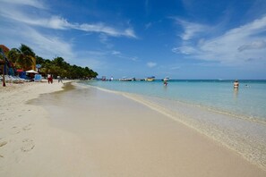 A beach with clear water, umbrellas, and boats. - Mission Gate 3A, 1-bedroom, 2-bath condo by Island House Vacation Rentals (West Bay)