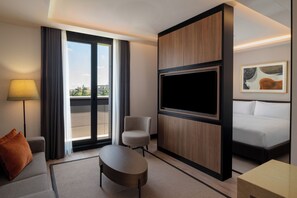 A hotel room with a sofa, armchair, TV, and a bed. - Altunizade Suites Istanbul, Curio Collection by Hilton (Istanbul)
