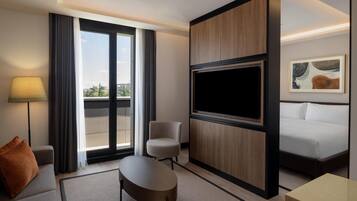 Deluxe-Zimmer, 1 King-Bett und Schlafsofa, Balkon, Stadtblick | Wohnbereich | 55-Zoll-LED-Fernseher mit Satellitenempfang, Bücher