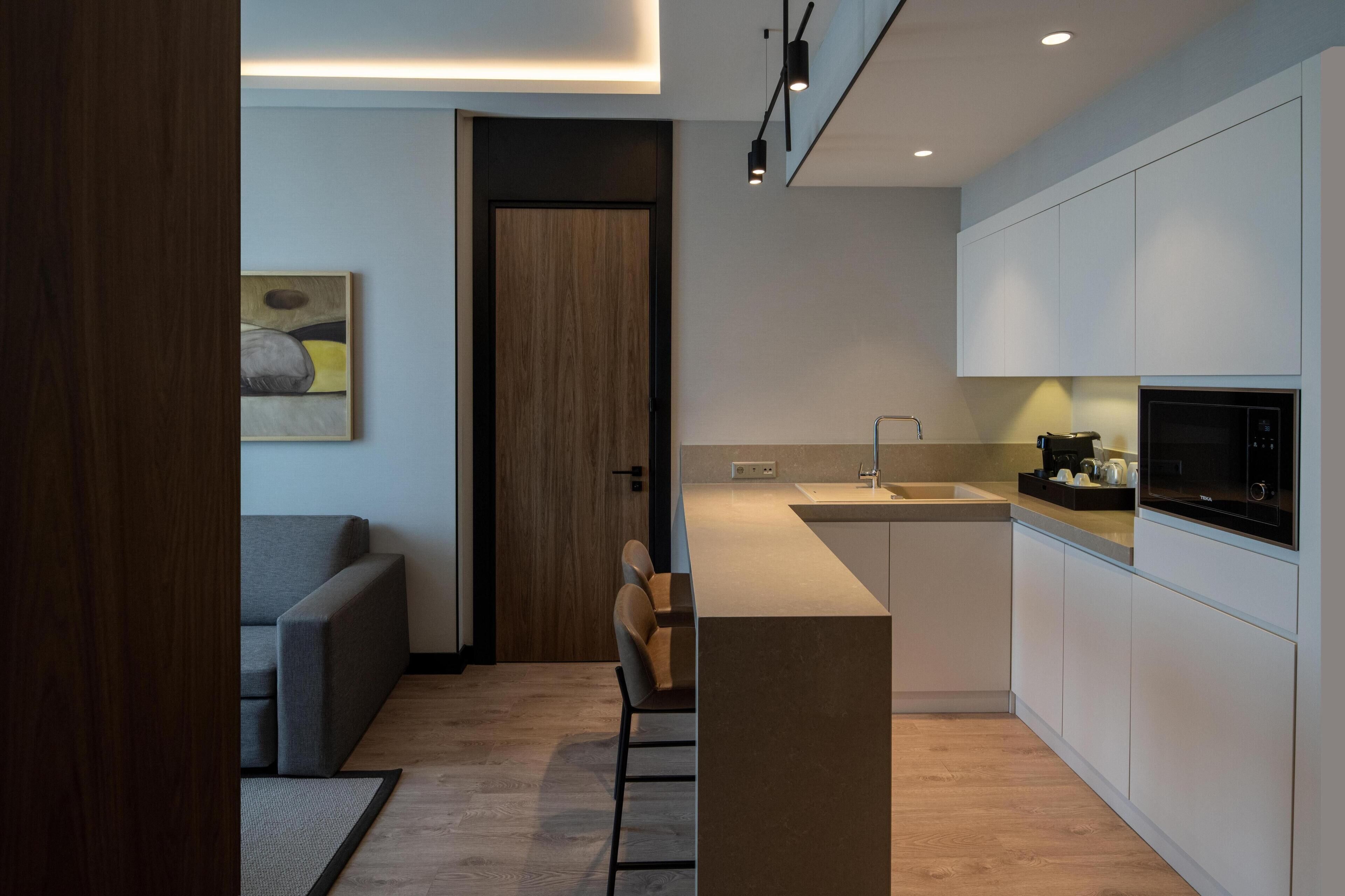 A modern kitchen with a built-in microwave, a coffee maker, and a small island.
