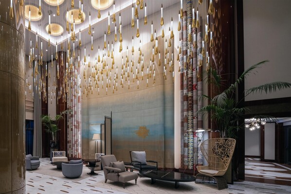 A spacious lobby with hanging light fixtures, seating areas, and a large wall mural. - Altunizade Suites Istanbul, Curio Collection by Hilton (Istanbul)