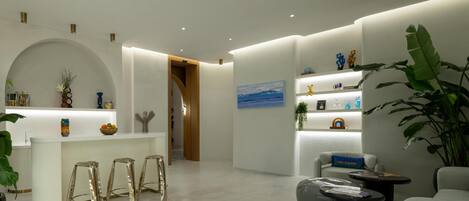 A modern interior with a reception desk, bar stools, seating area, and decorative elements.