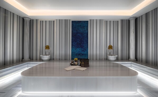 A modern bathroom with a large bathtub, marble walls, and a decorative blue panel. - Altunizade Suites Istanbul, Curio Collection by Hilton (Istanbul)