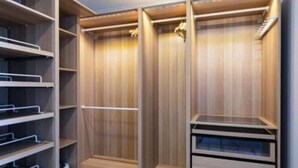A walk-in closet with wooden paneling, metal shelves, and drawers. - Carvajal Beach Apartment. Maravillosas Vistas (Benalmádena)