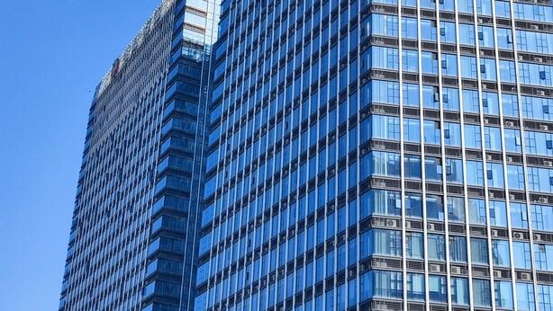A high-rise building with a modern glass facade, multiple floors, and a clear blue sky in the background. - Guangzhou Hantao International Apartment (Guangzhou)