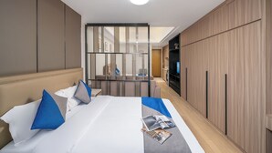 A hotel room with a large bed, a TV, and a wooden wardrobe. - Guangzhou Hantao International Apartment (Guangzhou)