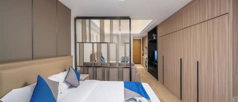 Habitación de hotel con una cama grande, un televisor y un armario de madera.