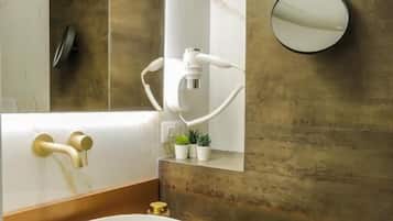 A modern bathroom with a large oval sink, a wall-mounted mirror, and a small potted plant.