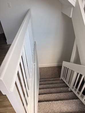A staircase with white railings and carpeted steps. - Stay close to shopping paradise! Apartment near Sawgrass and Hardrock stadium (Plantation)