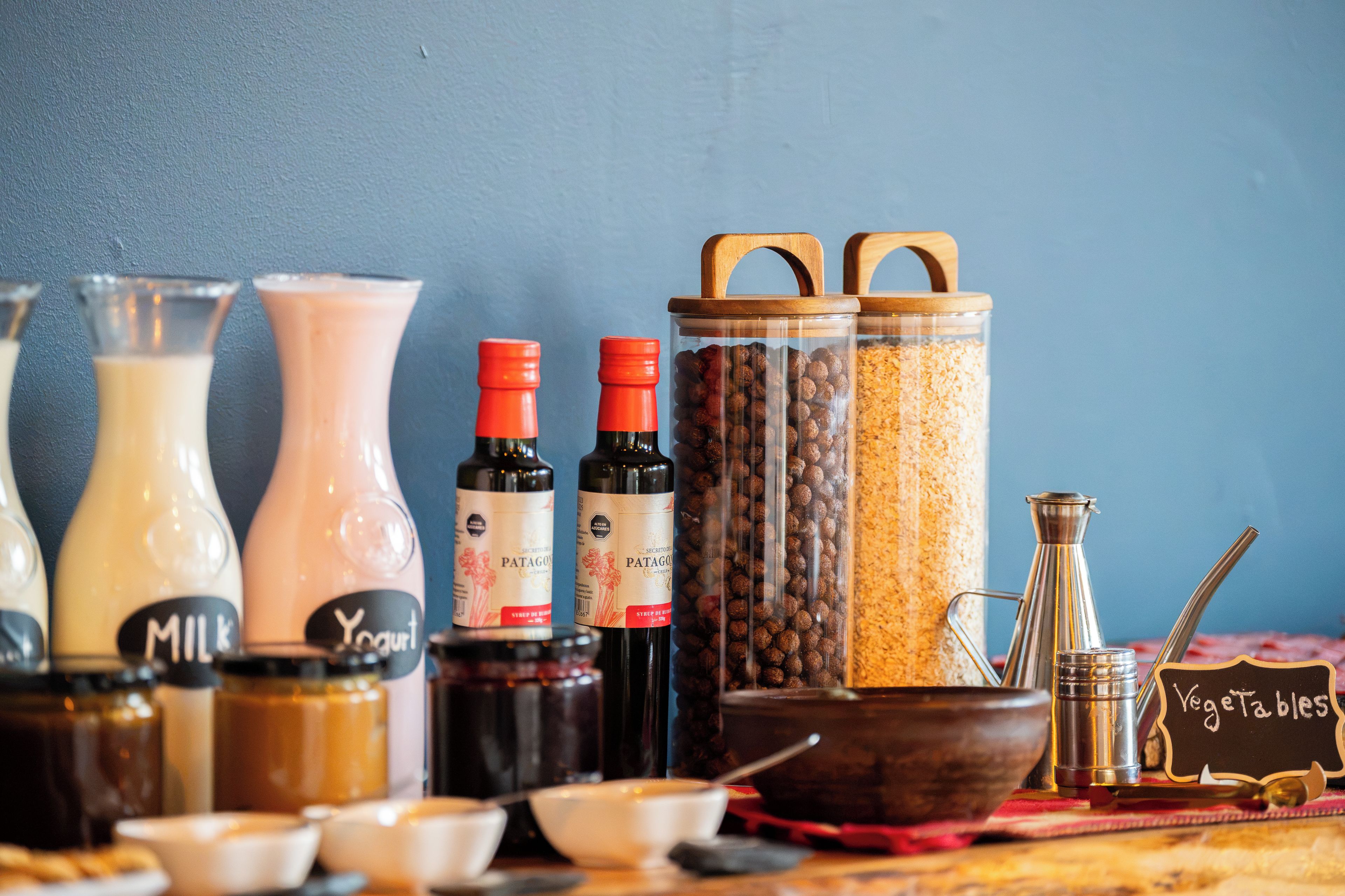 A variety of food and drink containers, including bottles and jars, on a table.