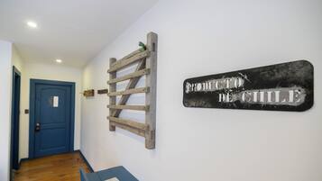 Um corredor com uma porta azul, uma escada de madeira e uma placa que diz 'PRODUTO DE CHILE'.