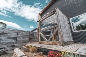 Ein rustikales Holzgebäude mit einem großen Fenster und einer Holzdiele.