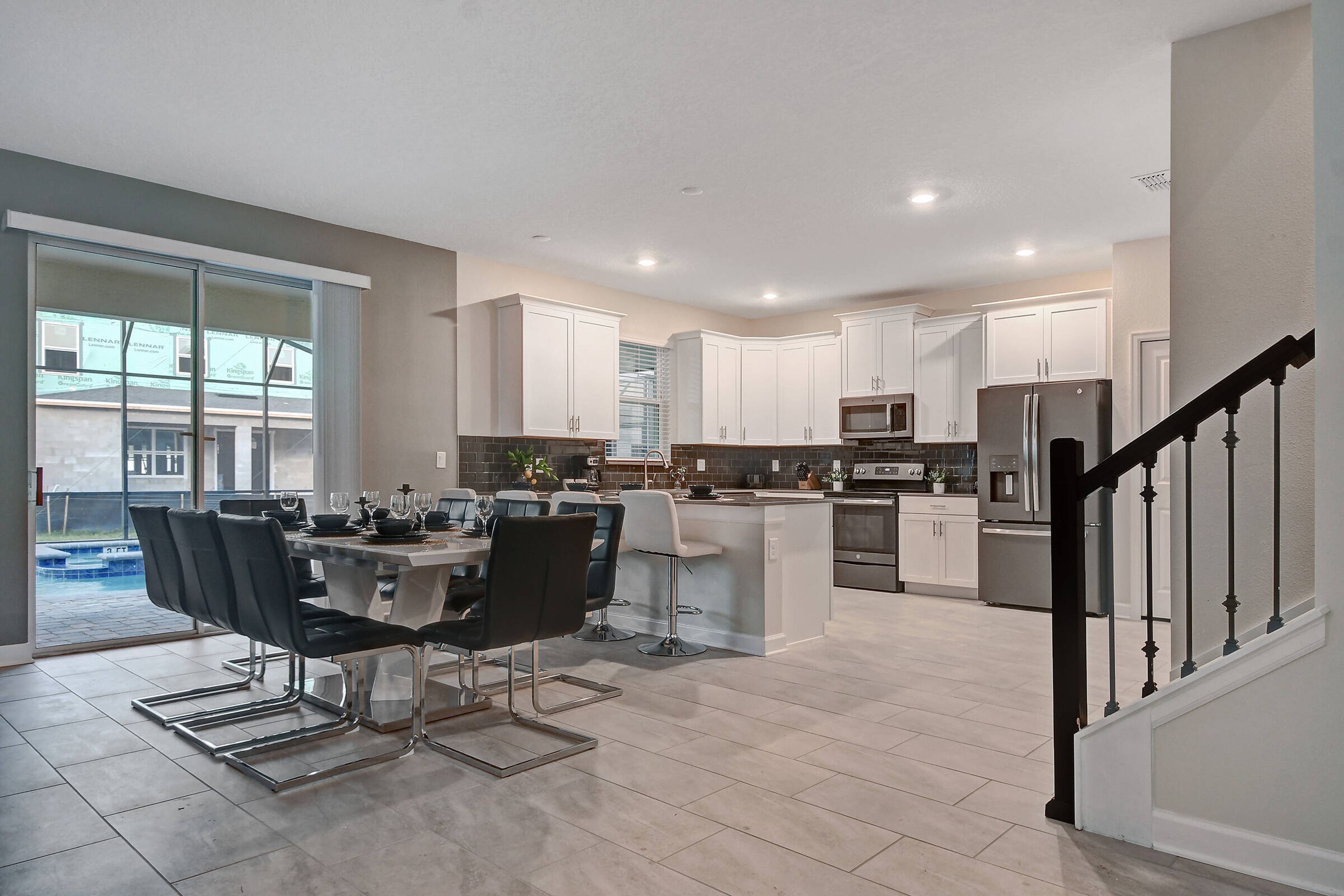 Une cuisine moderne avec des armoires blanches, des appareils en acier inoxydable et un îlot central.