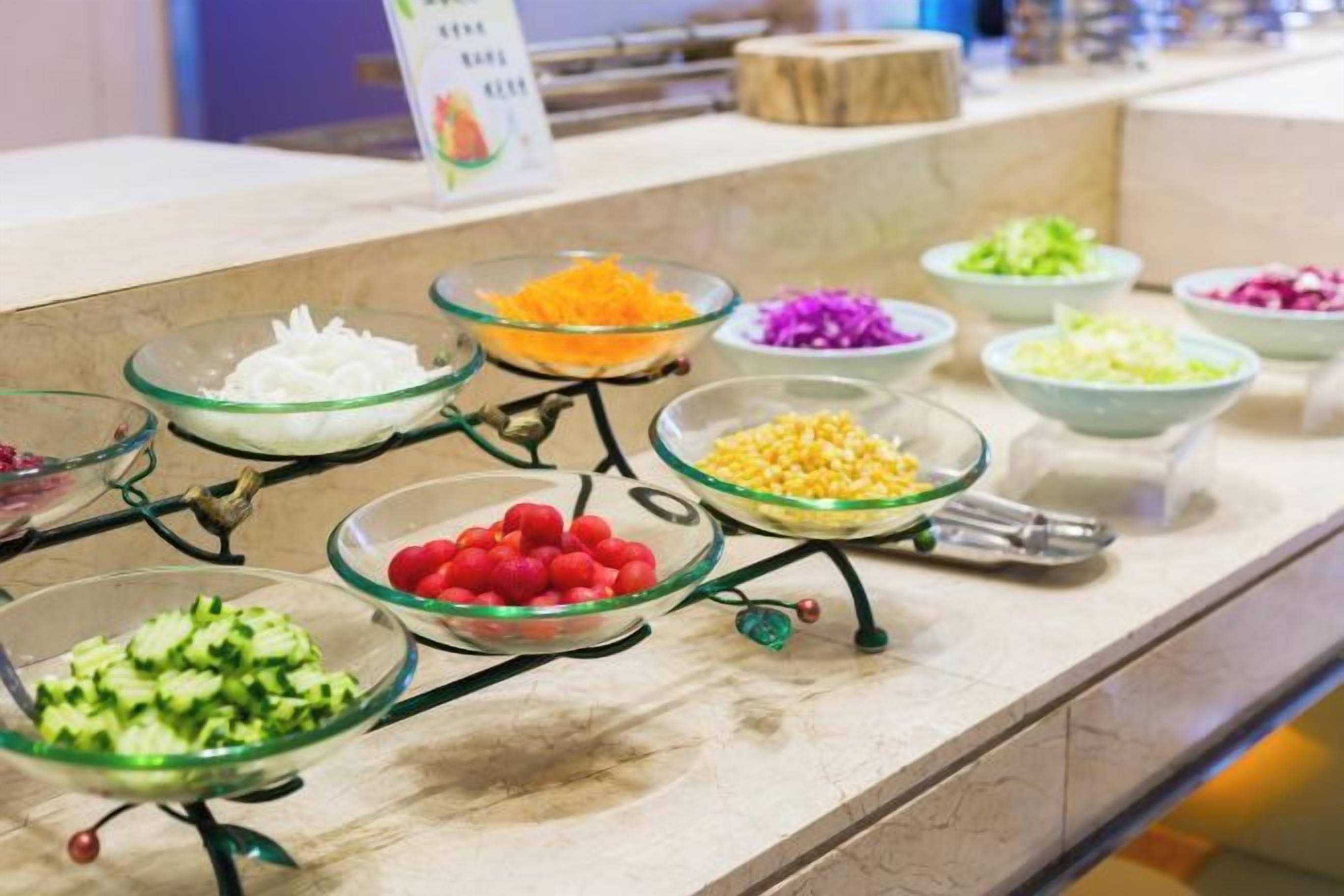 A buffet with various food items in glass bowls.