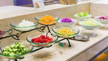 A buffet with various food items in glass bowls.