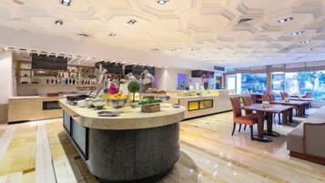 A hotel lobby with a central bar area, seating arrangements, and a view through the windows.