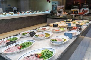 A buffet with various dishes displayed on a marble counter.