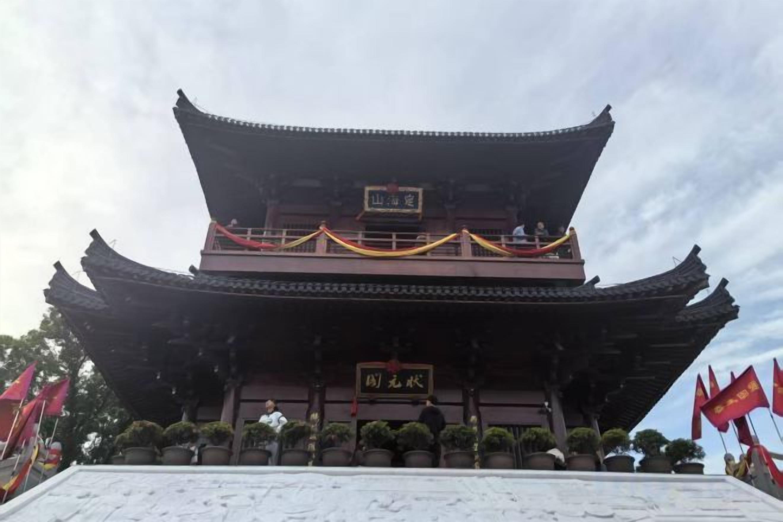 A traditional building with a multi-tiered roof and a sign in front.