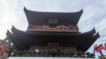 A traditional building with a multi-tiered roof and a sign in front.
