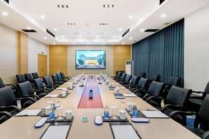 A conference room with a long table, chairs, and a presentation screen. - NEW OVERSEAS CHINESE HOTEL (Zhoushan)