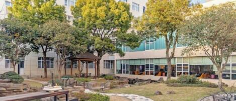 A courtyard with a gazebo, stone pathway, and outdoor seating area.