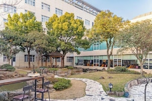 A courtyard with a gazebo, stone pathway, and outdoor seating area.