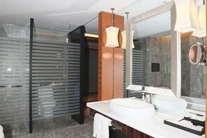 A modern bathroom with a large mirror, a round sink, and a glass partition. - Dongfang Mingyuan Hotel (Longchuan)
