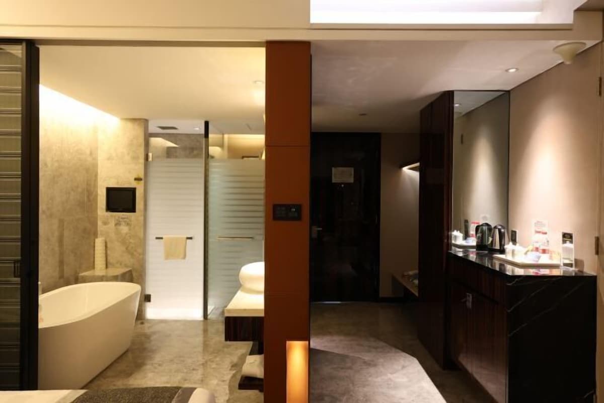 A modern bathroom with a bathtub, a shower area, and a vanity with toiletries.