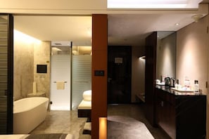 A modern bathroom with a bathtub, a shower area, and a vanity with toiletries. - Dongfang Mingyuan Hotel (Longchuan)