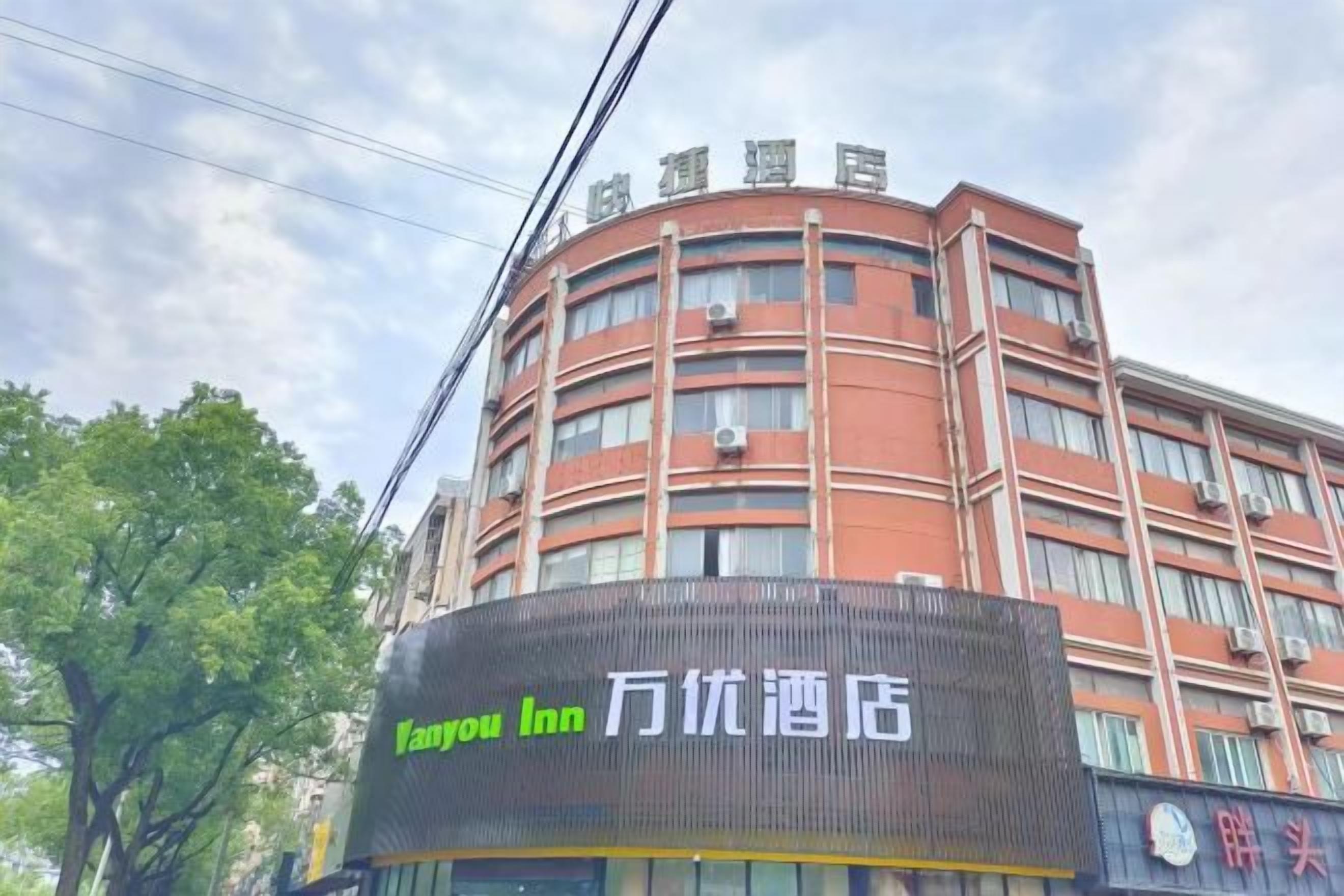 Un edificio a più piani con un grande cartello digitale per Vanyou Inn.