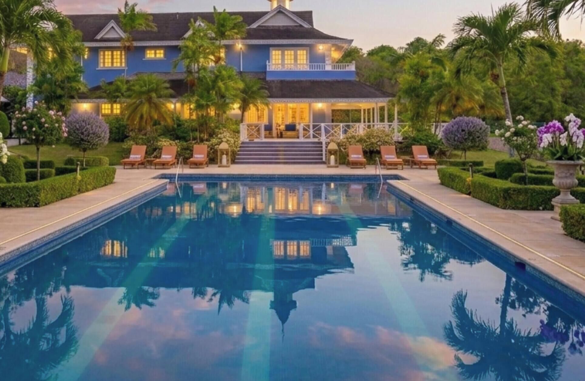 Une grande piscine avec des chaises longues et un jardin bien entretenu.