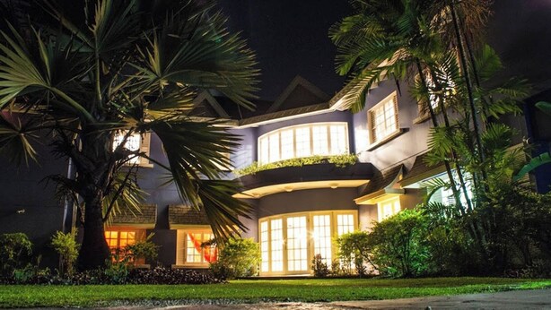 Un edificio de varios pisos con fachada curva, amplias ventanas y una entrada bien iluminada.
