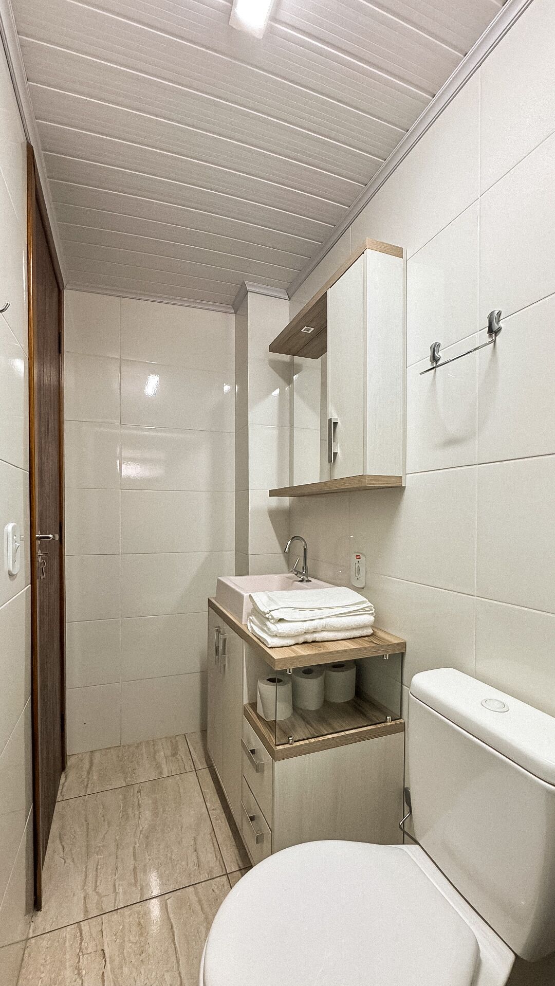 A small, modern bathroom with a toilet, sink, and mirror.
