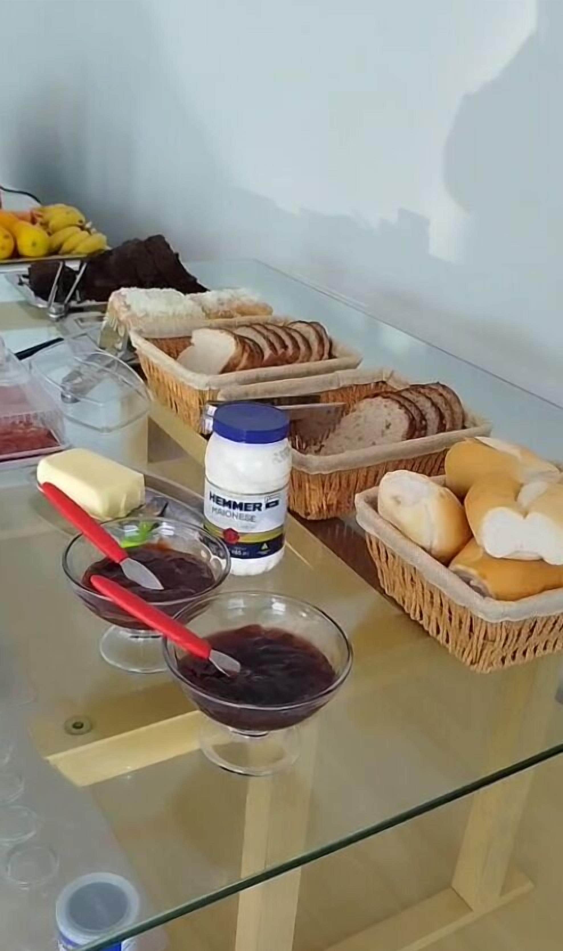 A table with various food items including bread, butter, and a jar of mayonnaise.