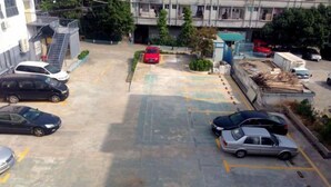 Ein Parkplatz mit mehreren Autos, einer Treppe und einem Gebäude im Hintergrund.