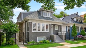 A two-story house with a front porch, a garage, and a well-maintained lawn.